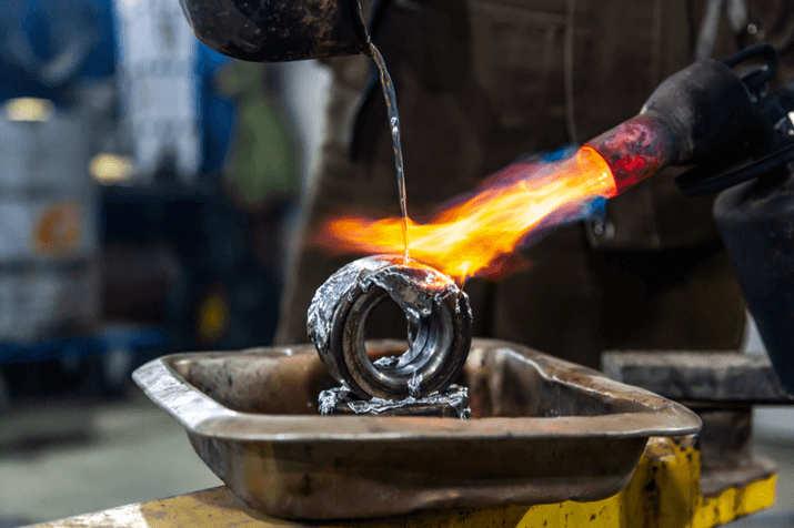 Professional male worker using a gas torch to melt lead metal