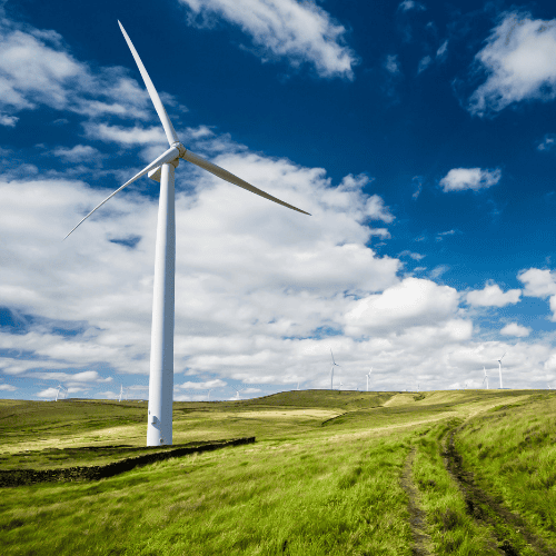 A wind turbine stands tall in a green field, symbolizing renewable energy and efforts to reduce the carbon budget
