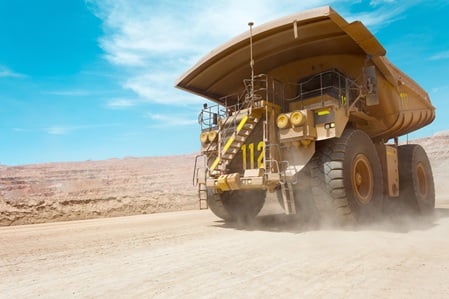 A dump truck moving in an open mine pit