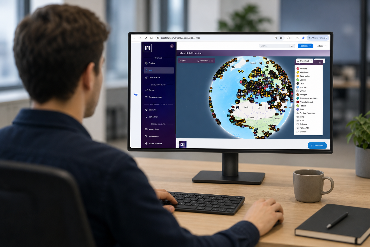 Person in an office whose sat at a desktop, navigating CRU's Asset Services platform and viewing a map for commodity asset data 