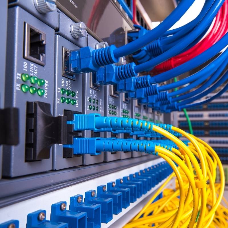 Close-up image of a network switch with various blue and yellow cables, representing trends in the wire and cable industry.