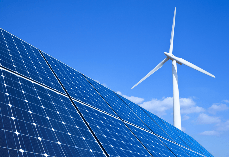 solar-panels-and-wind-turbine-against-blue-sky